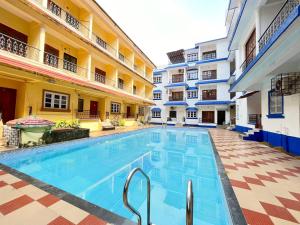 a swimming pool in the courtyard of a building at Tropical 1BHK Pool View Near Beach - Sia Stays in Candolim
