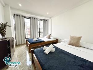 ein Schlafzimmer mit zwei Betten und einem großen Fenster in der Unterkunft Apartamentos Zona Circunvalar Por Parceros Group in Pereira