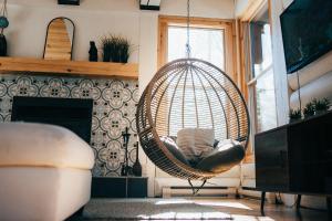 een kamer met een rotan stoel in een woonkamer bij Be zen with nature & enjoy private hot tub in Lac-Superieur