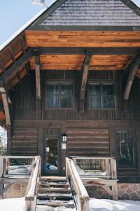 een houten huis met sneeuw op de trappen bij Be zen with nature & enjoy private hot tub in Lac-Superieur