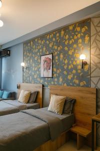 two beds in a room with a floral wallpaper at Hotel Graif Ti in Tbilisi City +126 photos
