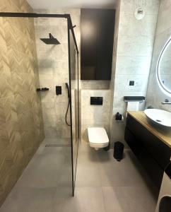a bathroom with a shower and a toilet and a sink at CityLine Apartment Nova Ochota in Warsaw