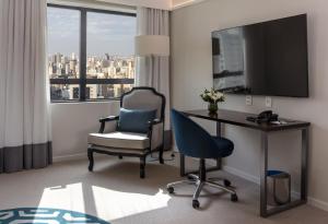 a hotel room with a desk and a chair and a television at Blue Tree Premium Paulista in Sao Paulo +96 photos