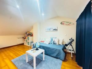 een slaapkamer met een blauw bed en een tafel bij Beach House in Fão