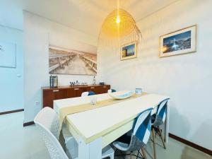 een eetkamer met een witte tafel en stoelen bij Beach House in Fão