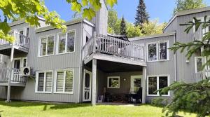 a large house with a deck and a balcony at Tremblant Ski Condo, Fast WIFI & Free parking in Mont-Tremblant
