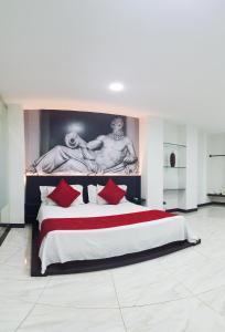 una habitación grande con una cama grande con almohadas rojas en Hotel Fenix, en Cúcuta