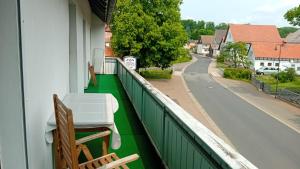 WaldkappelRJS Lambach GbR, Ferienwohnung am Dorfplatz的阳台配有桌椅和街道。