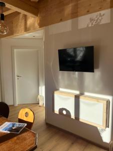 un salon avec une télévision sur un mur dans l'établissement amKampl-Ferienwohnung, à Radling