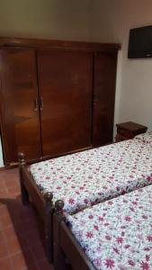Un dormitorio con una cama y una cómoda de madera. en Casaquinta con Piscina a Cuadras de la Playa, en Paso de la Patria
