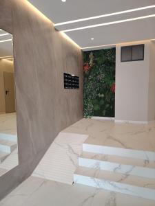 タンジェにあるRiad Salam Tangierの大理石の床と花が飾られた壁のあるロビー