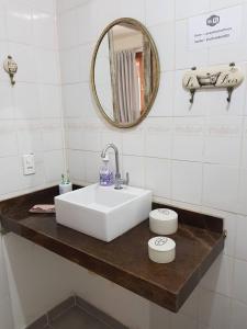 ein Badezimmer mit Waschbecken und Spiegel in der Unterkunft Suítes em Casa linda na Serra Paty do Alferes Rj in Paty do Alferes