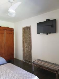 ein Schlafzimmer mit einem Bett und einem Flachbildfernseher an der Wand in der Unterkunft Suítes em Casa linda na Serra Paty do Alferes Rj in Paty do Alferes