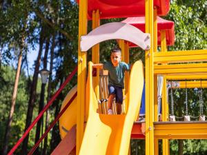 a young boy on a slide at a playground at Chalet by Pond in Eindhoven Holiday Park in Veldhoven