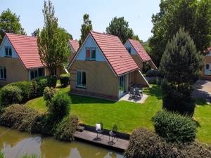 an aerial view of a house with a pond at Villa in Friesland with Garden by Water in Andijk