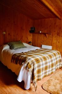 een slaapkamer met een bed in een houten kamer bij Casa Maqui Salto del Laja in Salto del Laja