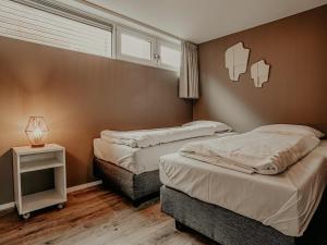 a bedroom with two beds and a table with a lamp at Houseboat in Netherlands with Private Dock in Uitgeest
