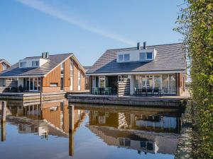 a row of houses on a body of water at Houseboat in Netherlands with Private Dock in Uitgeest