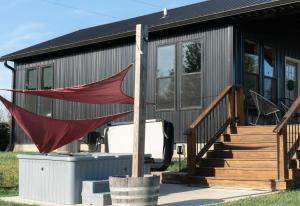 a house with a red flag in front of it at Bourbon Barrel Cottages #2 of 5 on Kentucky trail in Lawrenceburg
