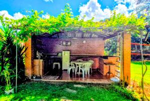 a patio with a table and chairs under a pergola at Pousada dos Chalés - Araras in Araras Petropolis