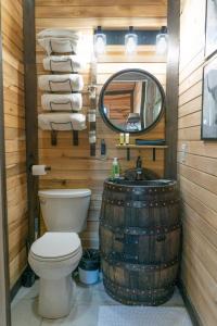 a bathroom with a toilet and a mirror and a barrel at Bourbon Barrel Cottages #2 of 5 on Kentucky trail in Lawrenceburg
