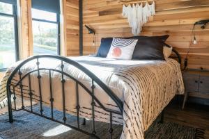 a bed in a room with a wooden wall at Bourbon Barrel Cottages #2 of 5 on Kentucky trail in Lawrenceburg