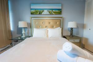 a bedroom with a large white bed with two lamps at Marena Seaview Condo in Dos Marinas, Fajardo in Beltran