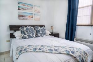 a bedroom with a white bed with blue and white pillows at Marbella | PH Rooftop Oasis in Costa Brava, Ceiba in Santa Maria +34 photos
