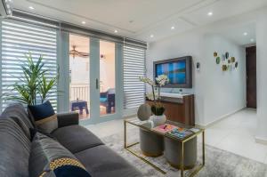 a living room with a couch and a television at Isla | The Sunset Abode in Ocean Club, Rincón in Corcega