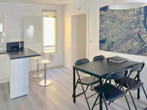 una sala da pranzo con tavolo e sedie neri di La Clé de Pierre a Saint-Germain-en-Laye