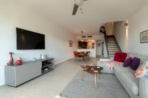 a living room with a couch and a tv at Selah | Travelers Nesters in Palmas Del Mar in Buena Vista