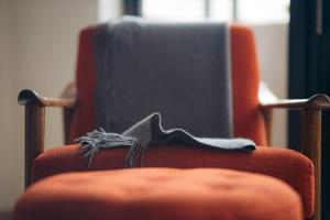 ein orangefarbener Stuhl mit einer Decke darauf in der Unterkunft Selah | Travelers Nesters in Palmas Del Mar in Buena Vista