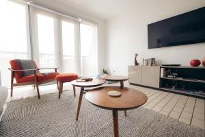 ein Wohnzimmer mit 2 Tischen und einem TV in der Unterkunft Selah | Travelers Nesters in Palmas Del Mar in Buena Vista