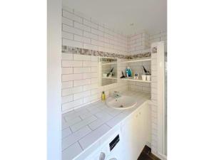 un bagno bianco con lavandino e specchio di La Clé de Pierre a Saint-Germain-en-Laye