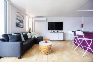 ein Wohnzimmer mit Sofa und Tisch in der Unterkunft ÁMARE | Cozy Beach Studio | Generator | Condado in San Juan