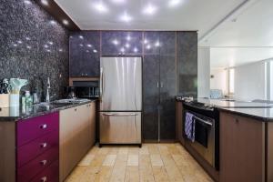 eine Küche mit lila Schränken und einem Kühlschrank in der Unterkunft ÁMARE | Cozy Beach Studio | Generator | Condado in San Juan + 15 Fotos