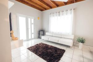 a white living room with a bench and a window at XELOR | Cozy Home | Generator/Cistern | Bayamón in Bayamón