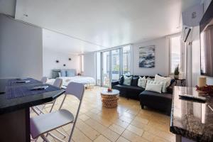 ein Wohnzimmer mit Sofa und Tisch in der Unterkunft ÁMARE | Cozy Beach Studio | Generator | Condado in San Juan