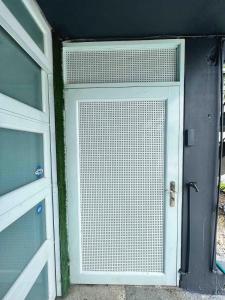 an open garage door with a white gate at XELOR | Cozy Home | Generator/Cistern | Bayamón in Forest Hills