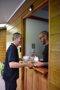 two men standing in a kitchen preparing food at Bungalows Paraíso Celeste in Bijagua