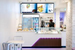 eine Frau steht hinter der Theke einer Bäckerei in der Unterkunft Blü Zen, Ideal Couple’s Stay in Mameyes Rio Grande in Mameyes