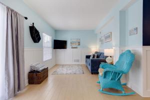 een woonkamer met een blauwe stoel en een bank bij Gorgeous Apartment on Mango St Steps to Beach in Fort Myers Beach