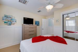 een slaapkamer met een wit bed met een rode strik erop bij Gorgeous Apartment on Mango St Steps to Beach in Fort Myers Beach