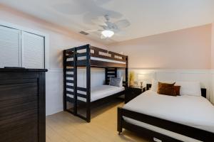 een slaapkamer met 2 stapelbedden en een plafondventilator bij Gorgeous Apartment on Mango St Steps to Beach in Fort Myers Beach