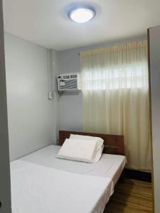 a small bedroom with two beds and a window at 2K2M Rental Units in Panglao +18 photos