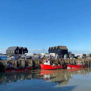 eine Gruppe von Booten liegt im Wasser vor Anker in der Unterkunft One Bedroom Ground Floor Flat in Whitstable in Whitstable