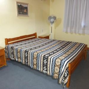a bedroom with a large bed with a striped blanket at Complejo Antilhue in Las Grutas