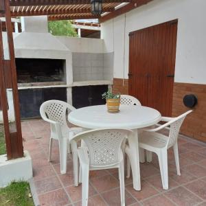 a white table and chairs on a patio at Complejo Antilhue in Las Grutas