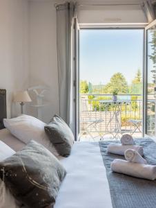 a bedroom with two beds with a view of a patio at Hôtel Blue Garden in Grandvillers