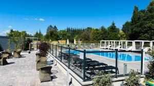 a swimming pool with lounge chairs at Logis Hôtel Blue Garden in Grandvillers
